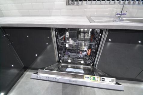 Modern kitchen featuring a built-in dishwasher ...