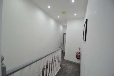 Bright and clean hallway with white walls and c...