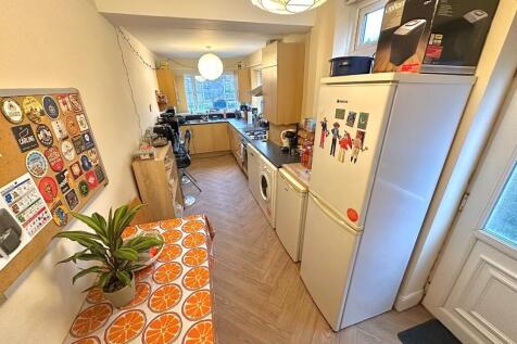 Bright galley kitchen with a long worktop, full...