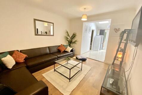 Bright, modern living room with a large L-shape...