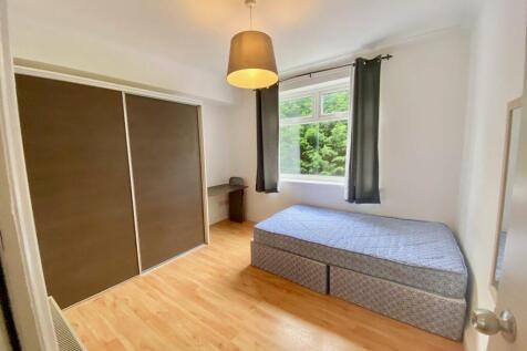 Bright, tidy bedroom with a large window lettin...