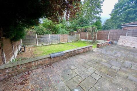 Private rear garden with a paved patio area lea...