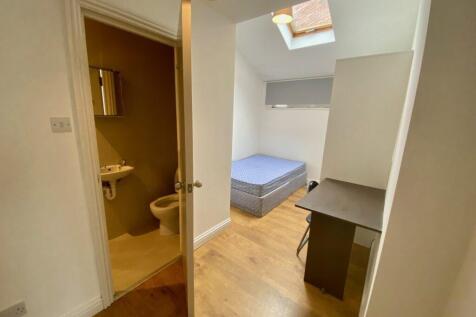 Compact furnished bedroom with a bed beneath a ...