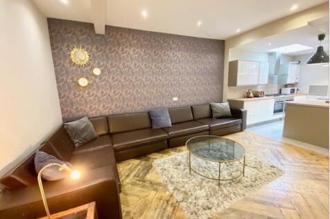 Stylish open-plan living area with a long leath...