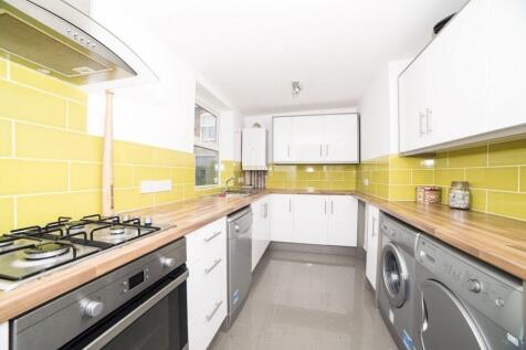 Bright modern galley kitchen with white cabinet...