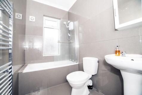 Bright, modern bathroom with a bathtub and sepa...