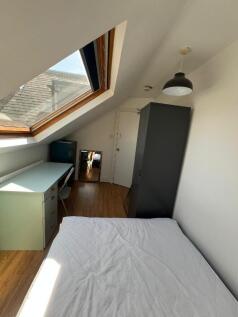 Bright and cozy single bedroom with a sloped ro...