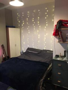 A cozy double bedroom featuring a well-made bed...