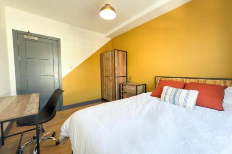 Bright, modern bedroom with a warm feature wall...