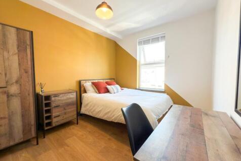 Bright, neatly furnished double bedroom with a ...