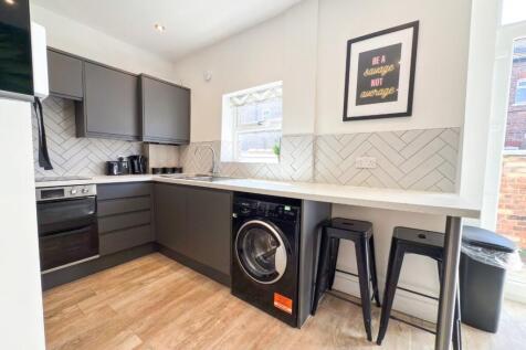 Modern fitted kitchen with sleek dark cabinets,...