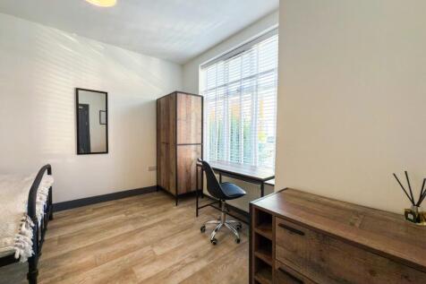 Bright, neatly presented bedroom with a large w...