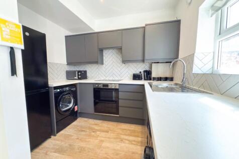 Bright modern kitchen with sleek grey cabinets,...