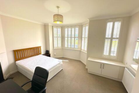 Bright double bedroom with a large bay window a...