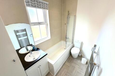 Bright, modern bathroom with a fitted bath and ...