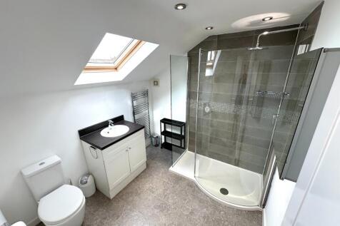 Bright, modern bathroom with a large corner sho...