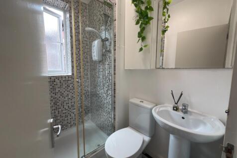 A modern bathroom featuring a shower enclosure,...