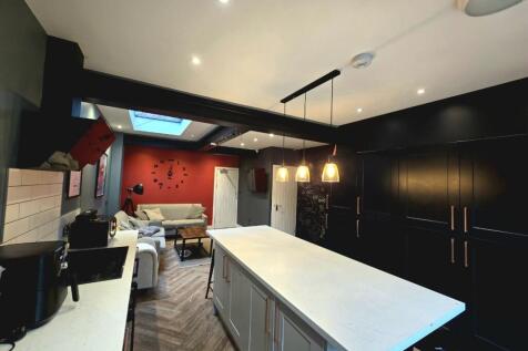 Modern and spacious kitchen featuring a large c...