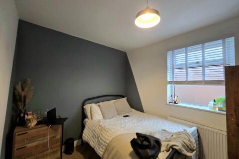 A spacious master bedroom featuring a comfortab...