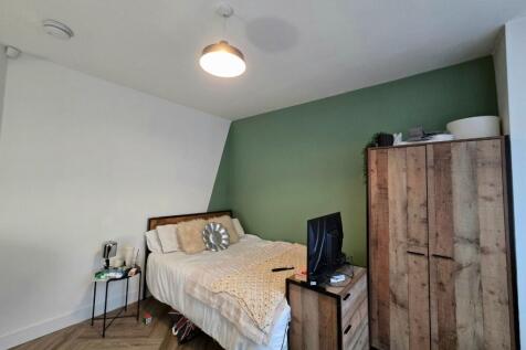 A cozy bedroom featuring a double bed, a bedsid...