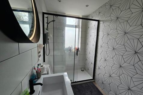 A modern bathroom featuring a walk-in shower wi...