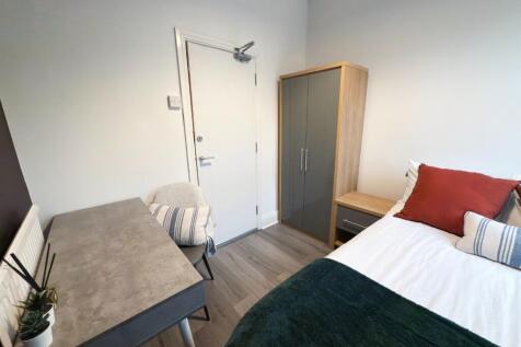 A cozy single bedroom featuring a comfortable b...