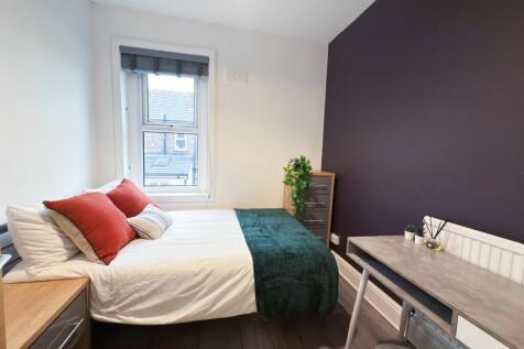 Bright and modern master bedroom featuring a co...