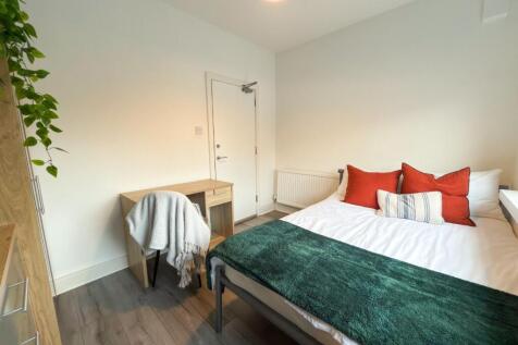 A bright and inviting bedroom featuring a comfo...