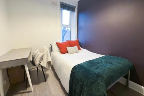 A cozy single bedroom featuring a comfortable b...