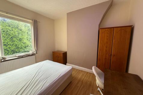 Bright, simply furnished bedroom with a large w...