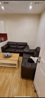 Cozy living area with two dark leather sofas ar...