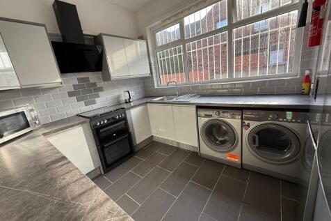 Bright, modern kitchen with sleek grey tiled fl...