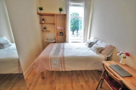 Bright, neatly furnished bedroom with a comfort...