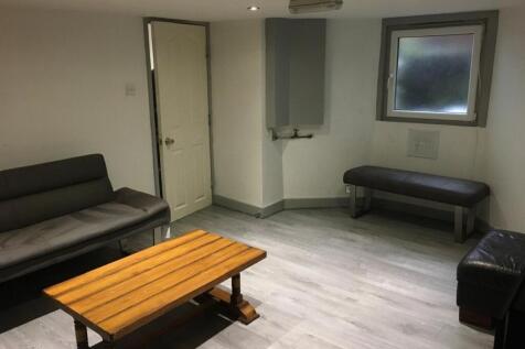 Bright, modern communal lounge with pale wood-e...