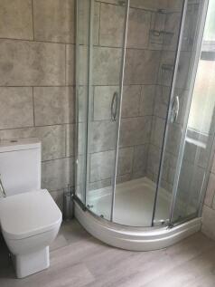 Modern bathroom with a corner glass shower encl...