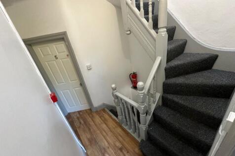 Bright, freshly painted entrance with a carpete...