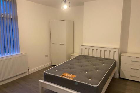 Bright, simply furnished bedroom with a double ...