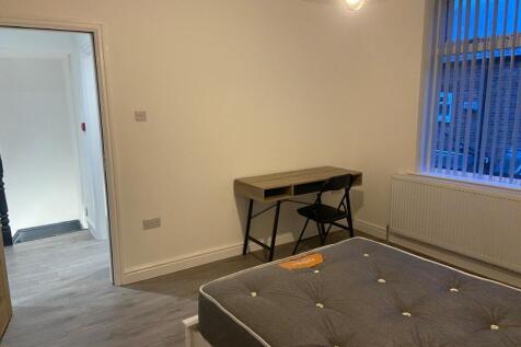 Bright, simply furnished bedroom with a comfort...