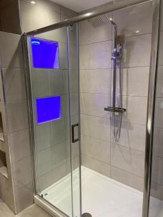 Modern tiled shower enclosure with a glass slid...