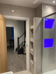 Modern bathroom with built-in shelving and a sl...