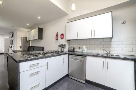 Modern galley-style kitchen with white cabinets...
