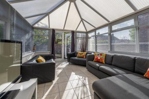 Bright, modern conservatory-style living room w...