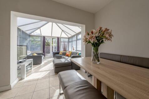 Bright open-plan living area with a dining benc...