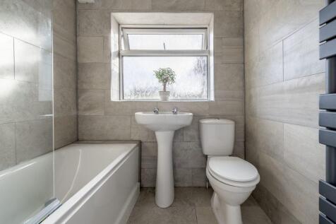 Bright, modern bathroom with a bathtub, pedesta...