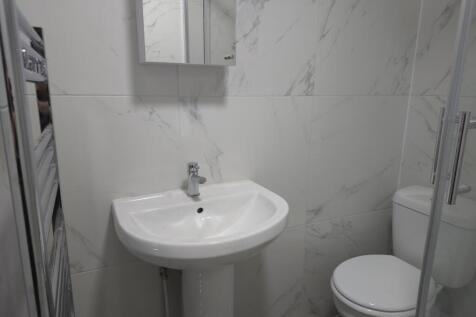 Bright, modern bathroom with a pedestal sink, m...