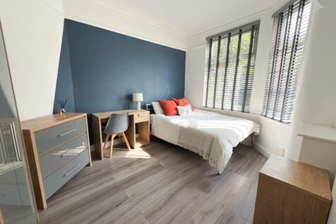 Bright, modern double bedroom with a feature bl...