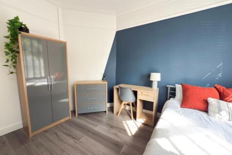 Bright, modern bedroom with a feature navy-blue...