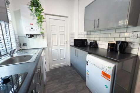 Bright modern kitchen with sleek grey cabinets,...