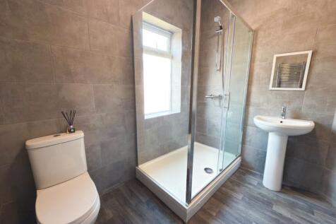 Modern bathroom with a corner glass shower encl...