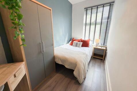 Bright, neatly styled double bedroom with conte...
